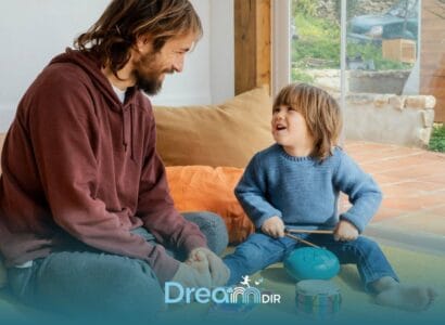 Therapist and autistic boy sit on carpet at home, joyfully playing instruments, smiling, & engaging in playful interaction.