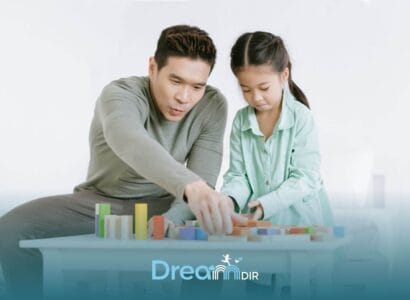 Therapist & autistic girl building with colorful blocks at a table, focusing on problem-solving & cooperative play at home
