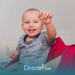 Autistic baby reaching forward while sitting on therapists lap, showing early social and developmental interaction cues