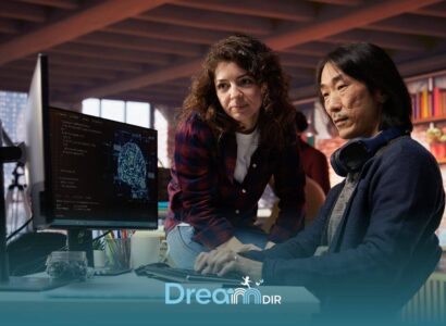 Two therapist collaborating at desk reviewing code and data on computer screen during hands-on technical training session