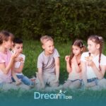 Group of autistic kids sitting on grass sharing snacks and interacting, representing social engagement and peer communication