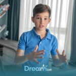 Autistic boy gesturing with hands while speaking indoors, illustrating communication skills and possible speech development.