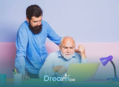 Therapist assisting autistic old man at laptop, pointing at screen while offering guidance and support