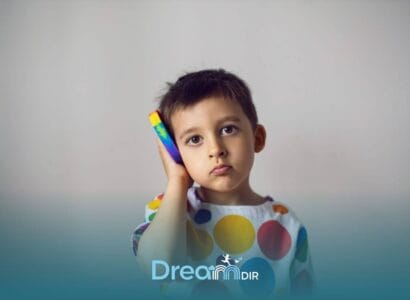 Autistic child holding a colorful toy phone to their ear, illustrating communication challenges & selective mutism in autism