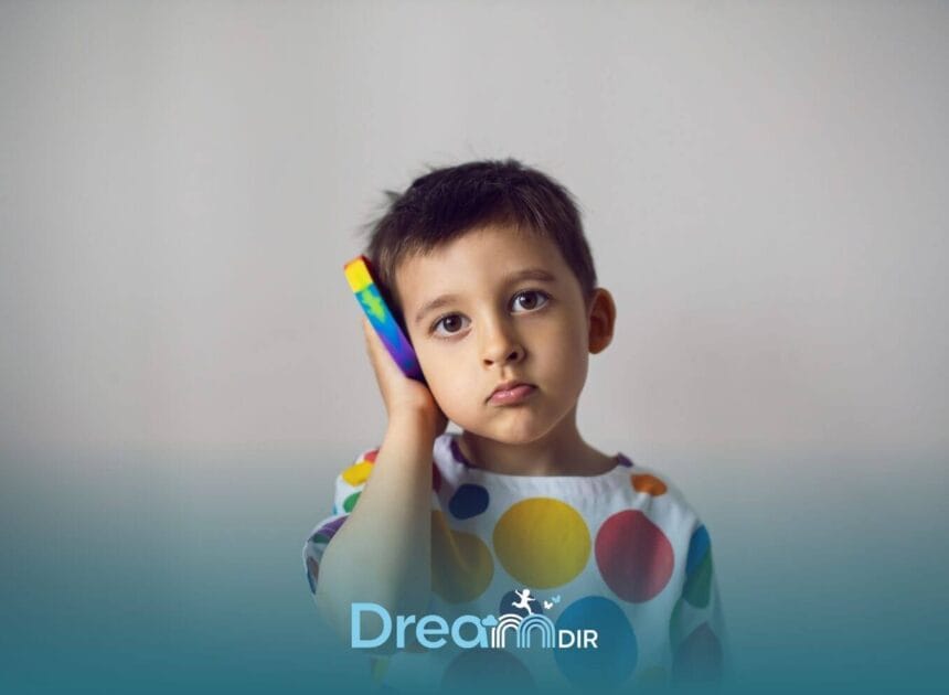 Autistic child holding a colorful toy phone to their ear, illustrating communication challenges & selective mutism in autism
