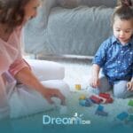 Therapist sitting with an autistic child on a carpet, encouraging play with colorful blocks to support focus