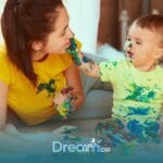 Therapist  & autistic boy engaged in messy sensory painting activity, building connection and creativity