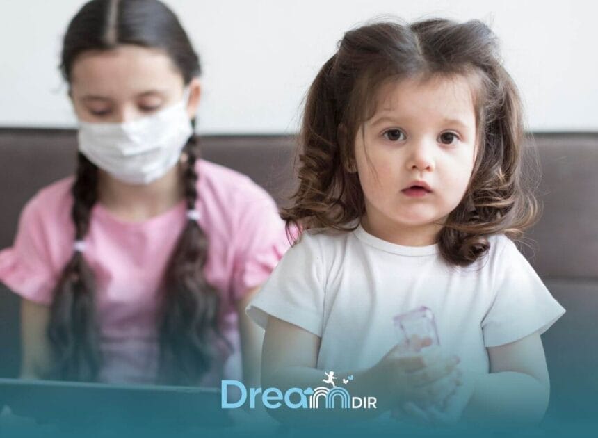 Autistic girl holding a bottle while caregiver wearing a mask uses a tablet during a pediatric therapy or assessment session